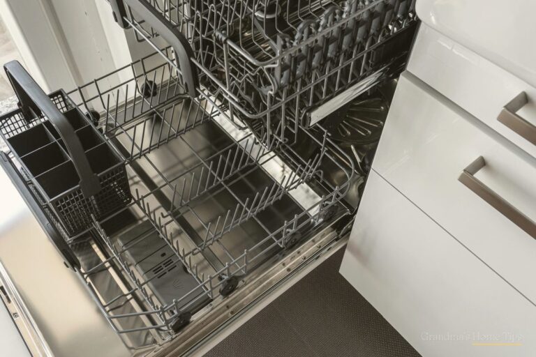 Open dishwasher with racks pulled out in a bright kitchen